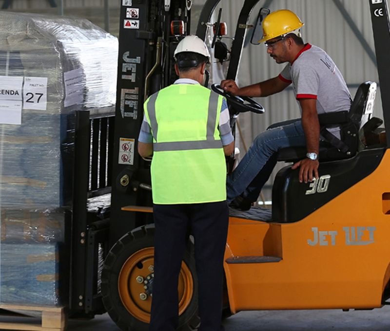 Depoda forklift kullanan operatör ve yükü kontrol eden görevli